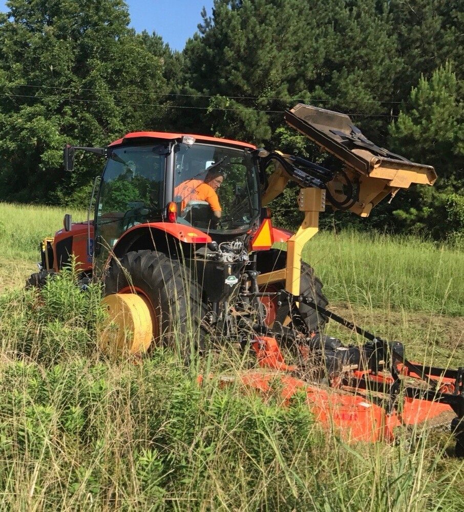 Brush Hog slowly lowers its trimmer to the grass.